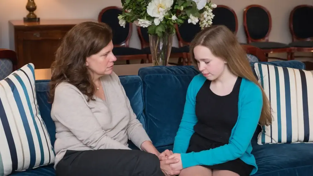 Mother comforting her grieving daughter during a funeral at Kane Fetterly Funeral Home in Montreal.