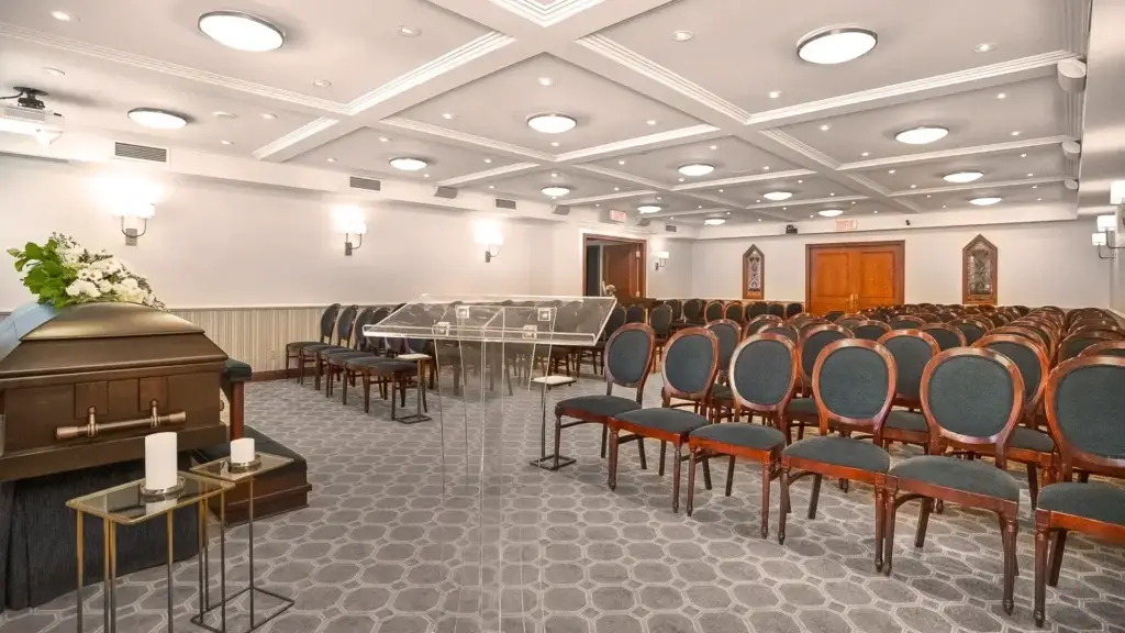 Chapel at Kane Fetterly Funeral Home in Montreal viewed from the podium, showing casket, floral tribute, and seating for guests