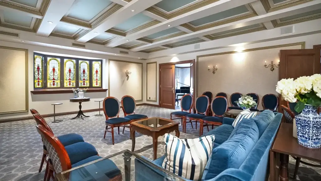 Room at Kane Fetterly Funeral Home in Montreal set up for a gathering with an urn, featuring elegant seating, floral arrangements, and soft lighting