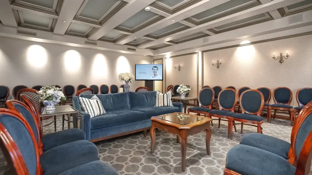 Room at Kane Fetterly Funeral Home in Montreal arranged for gathering or visitation with elegant seating, flowers, and a video tribute display