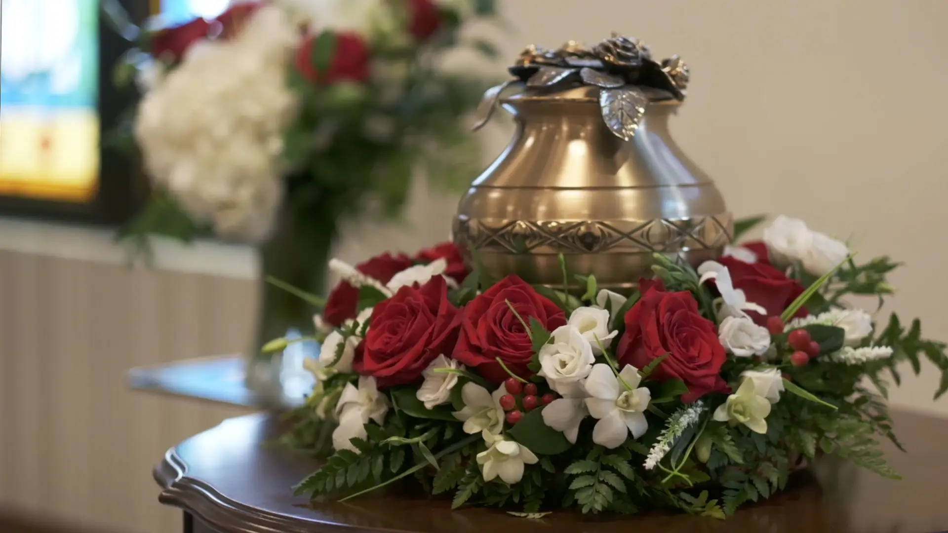 Urn surrounded by a floral tribute displayed at Kane & Fetterly Funeral Home for cremation services
