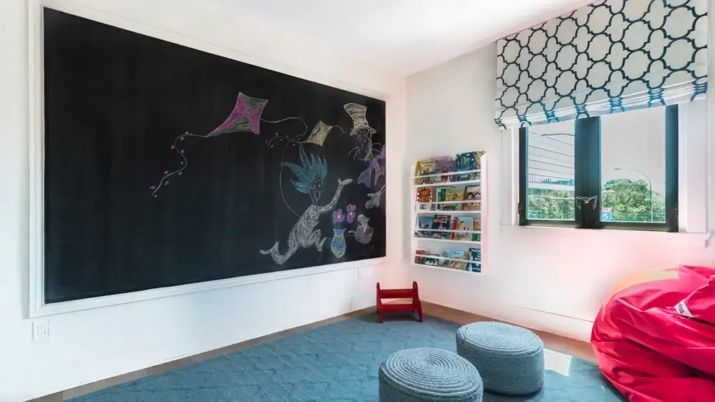 Children’s corner at Kane Fetterly Funeral Home in Montreal featuring a large chalkboard wall, book display, cozy seating, and natural light, offering a welcoming space for families with children